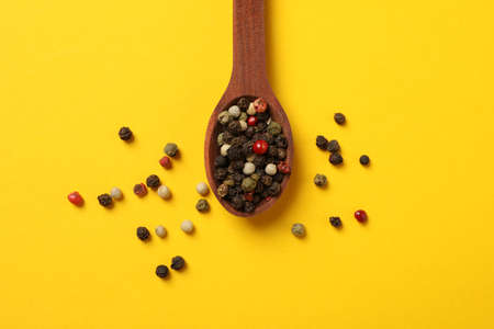 Wooden spoon with pepper spice on yellow background, top viewの写真素材