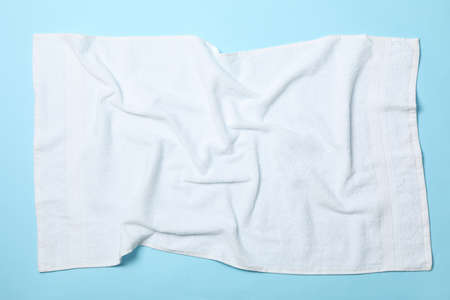 White crumpled towels on blue background, top view