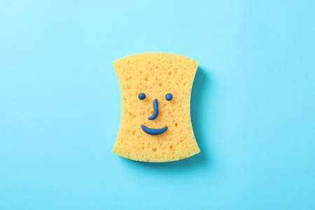 Sponge with smiley face on blue background, top viewの写真素材