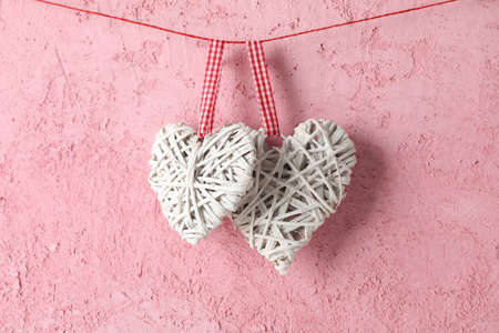 Decorative hearts hanging on pink background, space for text