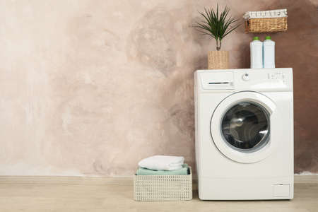 Laundry room with washing machine against brown wallの写真素材