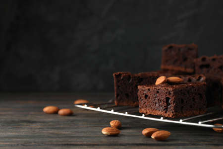 Chocolate cake slices and almond on wooden background, copy space