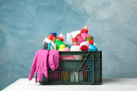 Basket with detergent and cleaning supplies on wooden table, copy spaceの写真素材