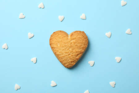 Heart shaped cookie on blue background with hearts, close upの写真素材