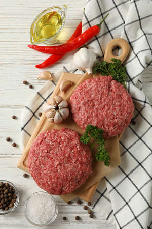 Spices and cutting board with minced meat on wooden background, top viewの写真素材