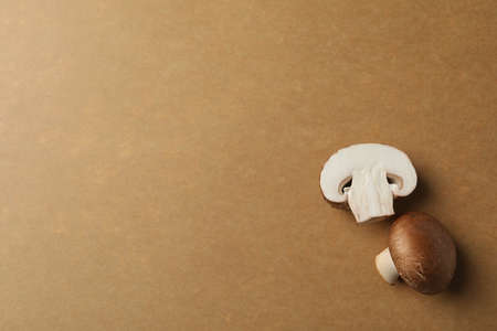 Champignons on brown kraft background, space for text