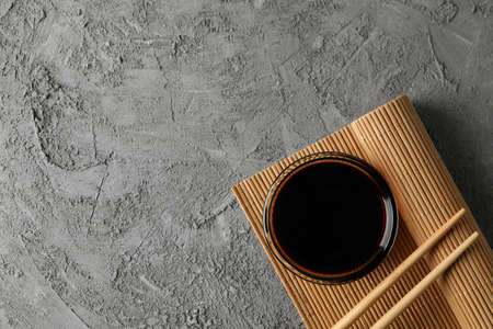 Bowl of soy sauce on gray background, space for text. Top viewの写真素材