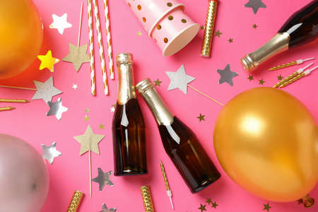Composition with champagne and birthday accessories on pink background, top viewの写真素材