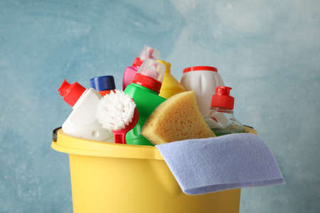 Bucket with detergent and cleaning supplies on blue background, close upの写真素材