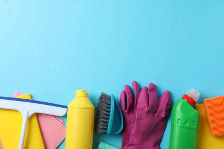 Bottles with detergent and cleaning supplies on blue background, space for textの写真素材