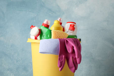 Bucket with detergent and cleaning supplies on blue background, close upの写真素材