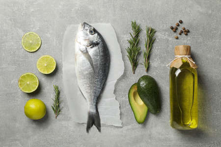 Dorado fish and cooking ingredients on grey background, top view