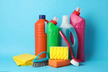 Bottles with detergent and cleaning supplies on blue background, space for textの写真素材
