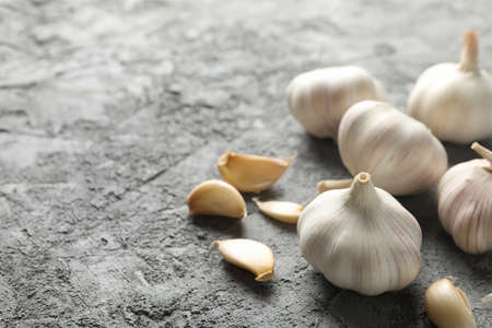 Garlic bulbs, slices on grey background, space for textの写真素材