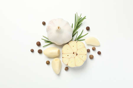 Garlic bulbs, slices, spice, parsley, rosemary on white background, top view. Space for textの写真素材