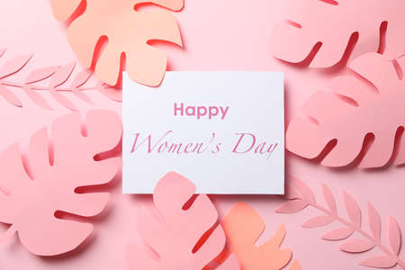 Decorative palm leaves and inscription Happy women's day on color background, top viewの写真素材