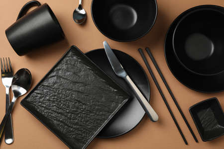 Tableware and cutlery on craft background, top view