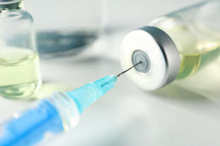 Medical syringe of vaccine, injection on gray background. Coronavirus protection. Healthcare and medical conceptの写真素材