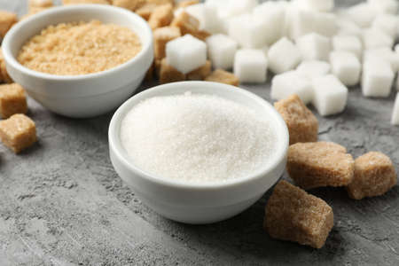 Bowls with sugar and sugar cubes on grey background, close upの写真素材