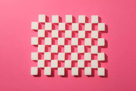 Flat lay with sugar cubes on pink background, top viewの写真素材