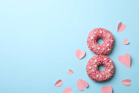 Eight made of donuts on blue background, top view