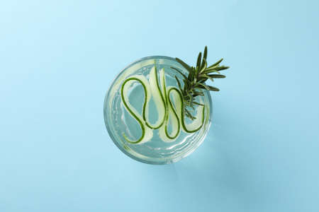 Glass with infused cucumber water on blue background, top viewの写真素材