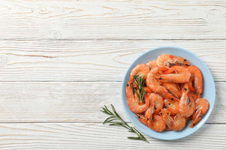 Plate with shrimps on wooden background, top viewの写真素材