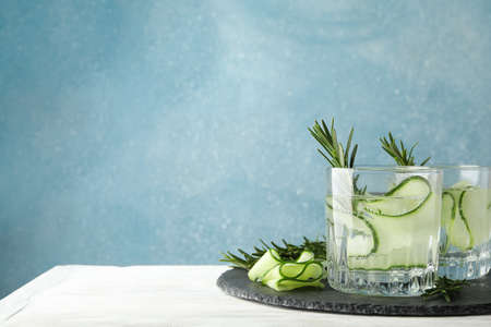 Glasses with cucumber water on tray on wooden table, space for textの写真素材