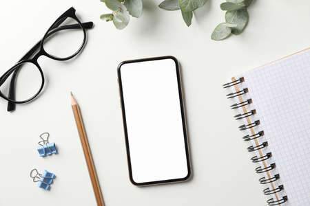 Workplace with phone with empty screen, top viewの写真素材