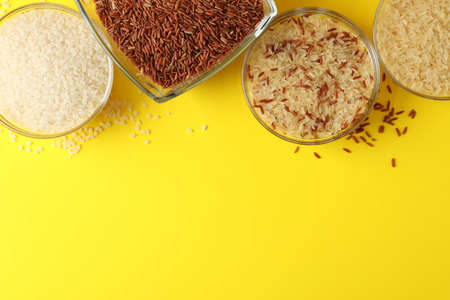 Bowls with different rice on yellow background, top viewの写真素材