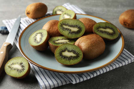 Composition with plate of ripe kiwi on grey table, close upの写真素材