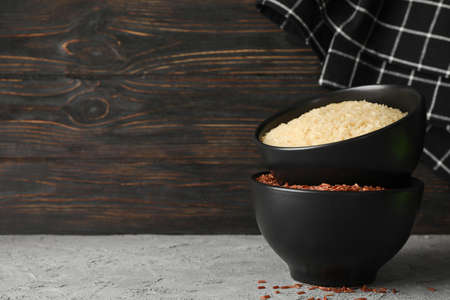 Bowls with rice and towel on grey table, space for textの写真素材