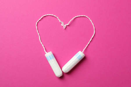 Heart made of tampons on pink background, top viewの写真素材