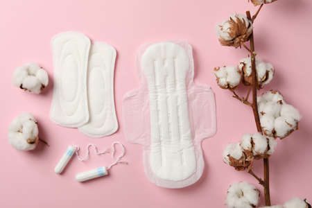 Sanitary pads, tampons and cotton on pink backgroundの写真素材