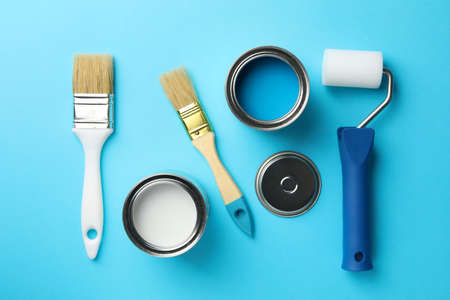 Paint cans, brushes and roller on blue background, top viewの写真素材