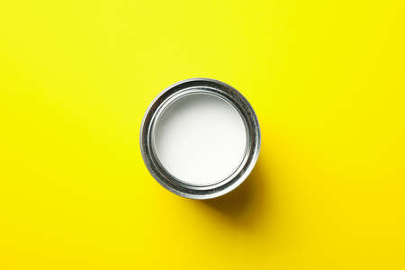 Paint can on yellow background, top view