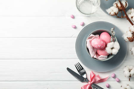 Easter table setting on white wood background, top view