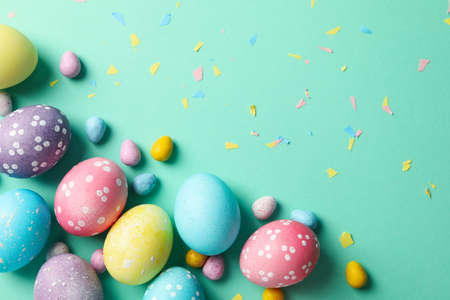 Multicolor Easter eggs on mint background, space for textの写真素材
