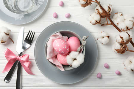 Easter table setting on white wood background, top view