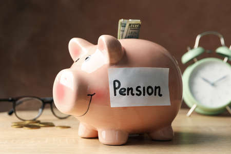 Piggy bank with inscription Pension against brown background, close upの写真素材