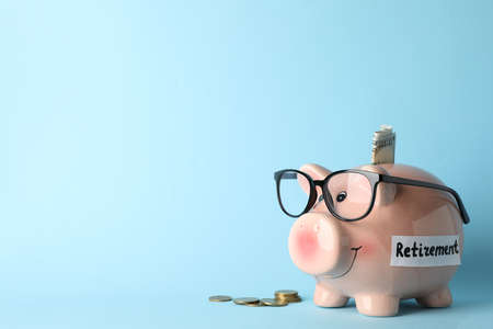 Piggy bank and money on blue background, space for textの写真素材