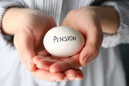 Woman holds egg with inscription Pension, close upの写真素材