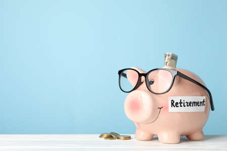 Piggy bank and money against blue background, space for textの写真素材
