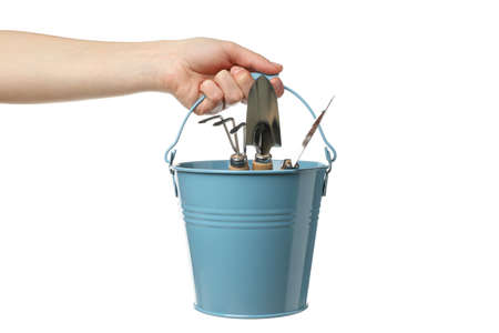 Person holds bucket with gardening tools, isolated on white backgroundの写真素材
