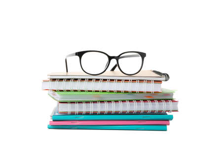 Pile of copybooks and glasses isolated on white background