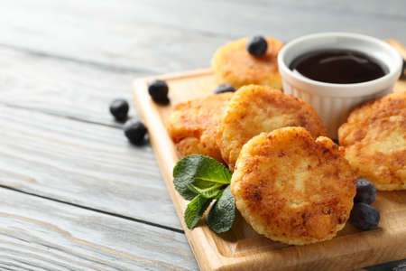 Breakfast of cheese pancakes on wooden background, close up