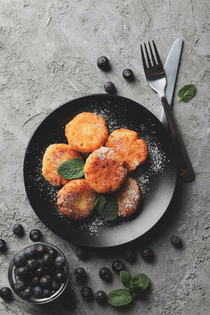 Breakfast of cheese pancakes on grey background, top viewの写真素材