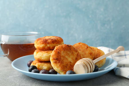 Breakfast of cheese pancakes against blue background, close up