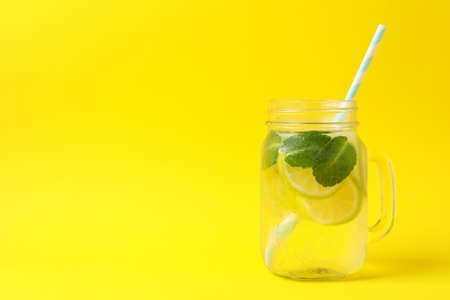 Glass jar with lemonade on yellow background. Fresh drinkの写真素材