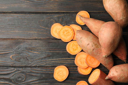 Sweet potato on wooden background, top viewの写真素材